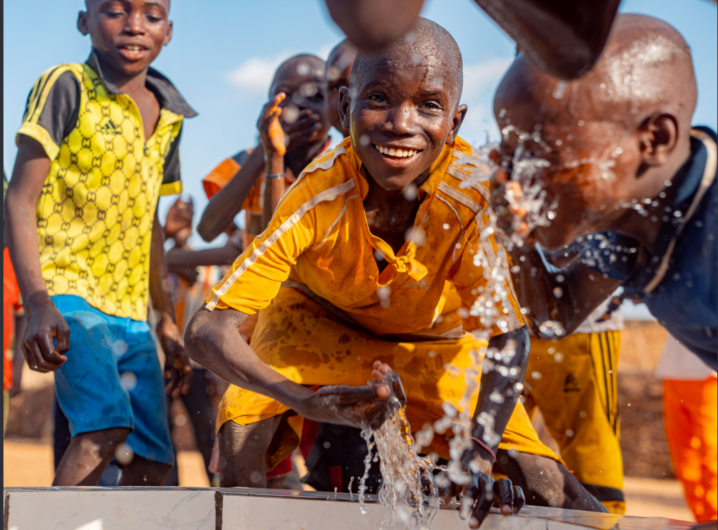 Des enfants se rafraîchissant autour d’un point d’eau